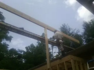 Carpenter setting a ridge beam over a new addition frame — Ice Dam Removal by Roofing Brothers in Silver Creek