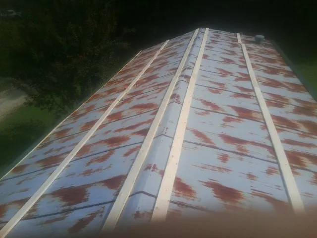 Rusted metal roof panels with new wood purlins before replacement — Storm Damage Roof Repair in Silver Creek by Roofing Brothers