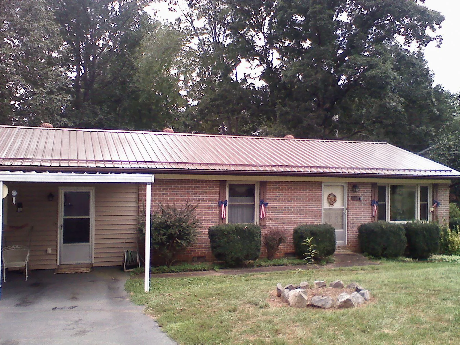 Bronze metal roof and carport on a brick ranch home — Roof Repair work by our crew in Silver Creek